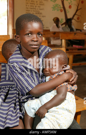 Boy holding enfant endormi, Sehitwa, Botswana, Africa Banque D'Images