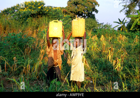 Deux enfants ougandais de transporter de l'eau pause à sourire pour la caméra Banque D'Images