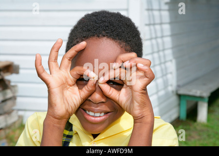 La formation 'fille' lunettes autour de ses yeux avec ses doigts à un couvent des Ursulines et orphelinat, Georgetown, Guyana, en Amérique du Sud Banque D'Images