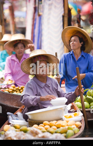 Marchands vendant fruits fruits dans un bateau au marché flottant de Damnoen Saduak Banque D'Images