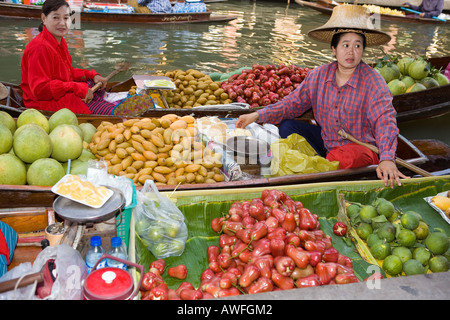 Marchands vendant fruits fruits dans un bateau au marché flottant de Damnoen Saduak Banque D'Images
