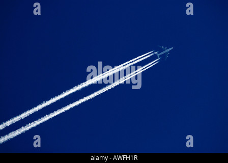 Avion dans un ciel bleu, les traînées d'échappement (trail, traînée de vapeur) Banque D'Images