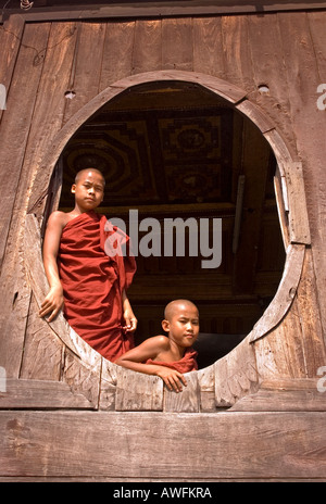 Stock photo de deux jeunes moines dans une fenêtre à Shwe Yaunghwe Kyaung monastère à Nyaungshwe au Myanmar Banque D'Images