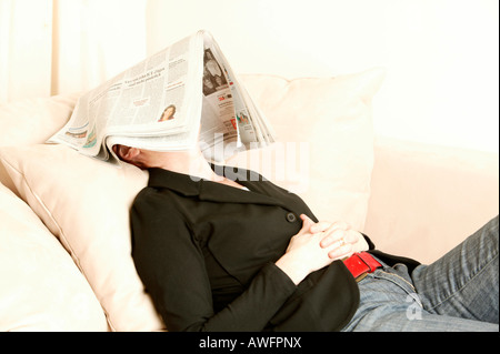 Femme d'âge moyen avec du papier journal sur son visage Banque D'Images