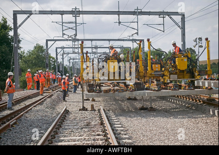 Rail Contractors en utilisant le système de remplacement modulaire pour remplacer le matériel usé par la voie de l'installation des panneaux préfabriqués sur un chemin de fer d'occupation Banque D'Images