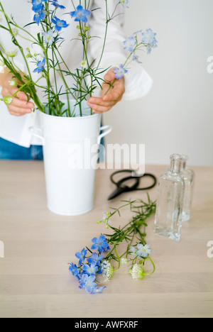 Une femme l'organisation des fleurs dans un vase Banque D'Images