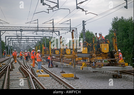 Rail Contractors en utilisant le système de remplacement modulaire pour remplacer le matériel usé par la voie de l'installation des panneaux préfabriqués sur un chemin de fer d'occupation Banque D'Images