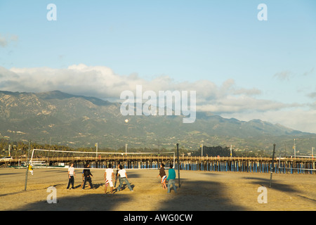 CALIFORNIA Santa Barbara les élèves du secondaire à jouer au volleyball de plage sur la plage ouest Stearns Wharf et montagnes en arrière-plan Banque D'Images