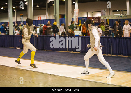 SPORTS combat escrime fleuret masculin concurrents sur le strip au cours de match se précipitant vers l'adversaire de spectateurs regardant Banque D'Images