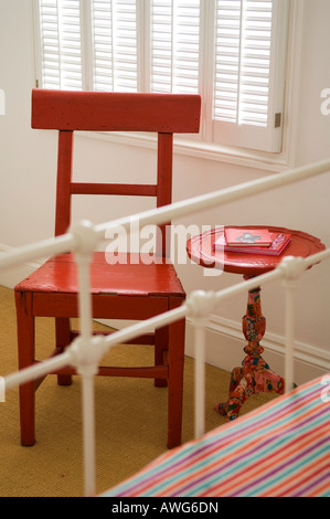 Chaise en bois rouge et table circulaire au pied de lit en fer forgé Banque D'Images