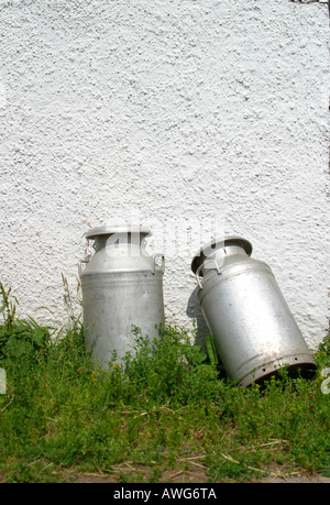 Des bidons de lait leaning on wall Banque D'Images