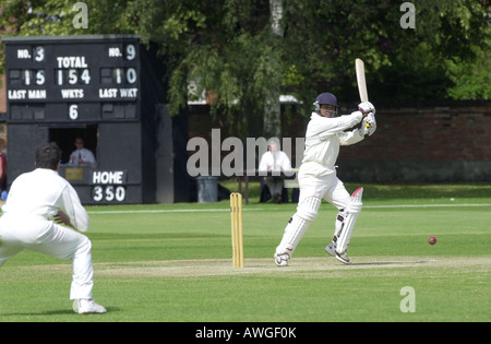 Un batteur sculpte le ballon dans un match de cricket UK Banque D'Images