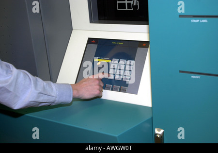 Un homme utilise une machine automatique Banque D'Images