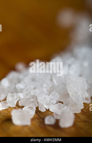 Stock photo d'un gros plan de gros sel de mer le sel des granules se repose sur une table de cuisine en bois Banque D'Images