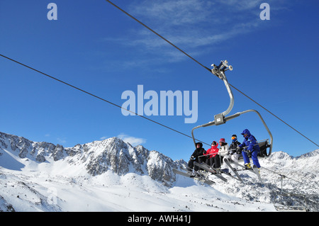 Skieurs sur un téléski de l'Andorre, les Pyrénées en arrière-plan, pas de la station de ski Banque D'Images