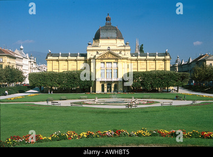 Croatie, Zagreb, Pavillon des Arts, façade de hall d'exposition, partiellement obscurci par les buissons, avec vue sur étang Banque D'Images