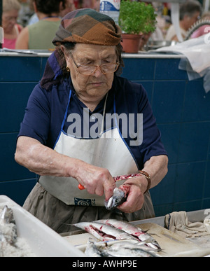 Une femme l'éviscération du poisson et fruits de mer à un vend un décrochage dans le grand marché couvert mercado central ou dans la région de Figueira da Foz Portugal Banque D'Images