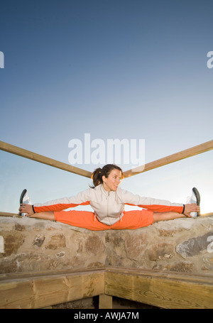 Jeune femme en vêtements de sport stretching Banque D'Images