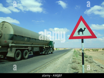 La Jordanie, le tanker sur route près de camel crossing sign Banque D'Images