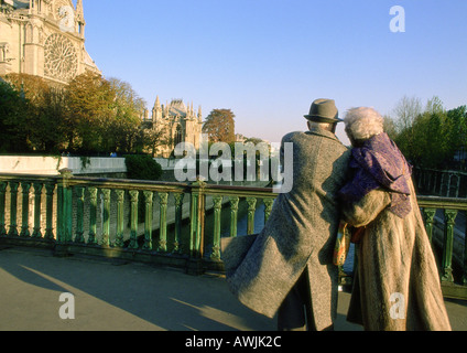 France, Paris, young couple walking arm in arm sur le pont à côté de la Cathédrale Notre-Dame Banque D'Images