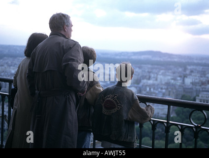 Groupe de personnes debout par rail avec vue sur ville Banque D'Images