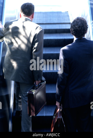 Hommes d'équitation escalator, vue arrière. Banque D'Images