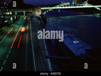 France, Paris, voitures voyageant sur le quai le soir, floue. Banque D'Images