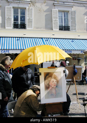 France Paris Montmartre Place du Tertre avec portrait de l'artiste sur chevalet et parapluie jaune Banque D'Images