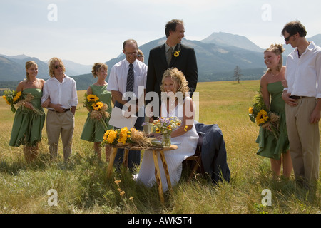 Eliza et Adam signent leur certificat de mariage romantique sur une colline d'or dans les Montagnes Rocheuses de l'Alberta, Canada Banque D'Images