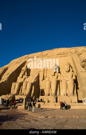 Temple d'Abou Simbel, des statues de Ramsès II en début de matinée avec les touristes soleil Egypte Afrique du Nord Banque D'Images