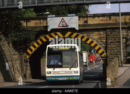 Un autobus qui passe sous le pont de chemin de fer leeds uk Banque D'Images