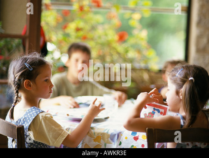 Des enfants assis autour de la table Banque D'Images