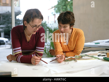 Deux femmes se penchant sur la table, enclos Banque D'Images