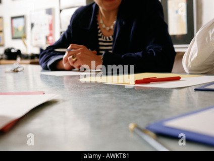 Femme assise au bureau, vue partielle Banque D'Images