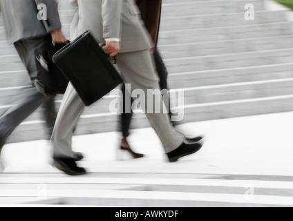 Business people walking, low section, brouillées, b&w Banque D'Images