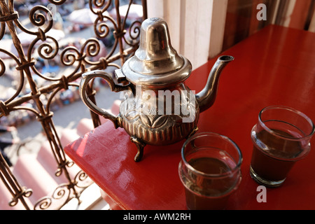 Théière marocaine très orné et verres sur une table rouge dans le quartier historique de Médina, Marrakech, Maroc, Afrique Banque D'Images