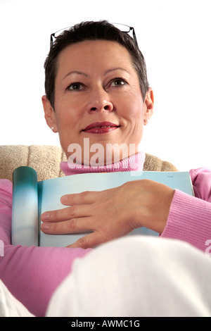 Femme assise confortablement sur canapé Banque D'Images