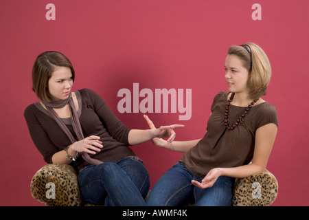 Deux jeunes filles, pré-adolescents, jeunes adolescents assis sur un tigre-impression de parler de la table Banque D'Images