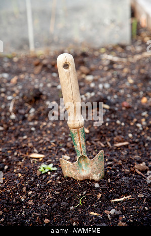 Bien utilisée la truelle de jardin planté dans le sol Banque D'Images