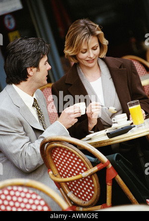 Businessman and businesswoman sitting at cafe terrace Banque D'Images