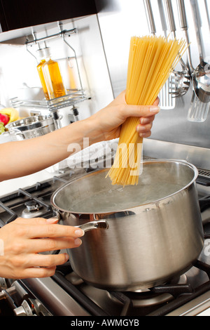 WOMAN IN KITCHEN COOKING SPAGHETTI Banque D'Images