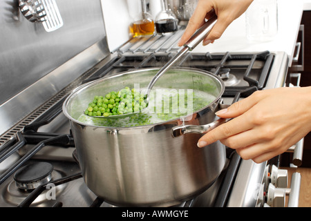 Femme DANS LA CUISINE CUISINE POIS Banque D'Images