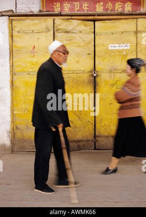 La Chine, la Province du Xinjiang, Turpan, vieil homme marcher avec la canne passé restaurant fermé Banque D'Images