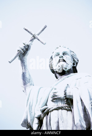 Statue de man holding crucifix, low angle view Banque D'Images