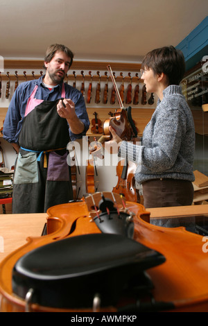 Luthier (luthier) avec un client dans sa boutique Banque D'Images