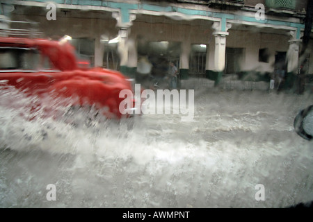 American Vintage car la conduite sur une route inondée de pluie à La Havane, Cuba, Caraïbes Banque D'Images