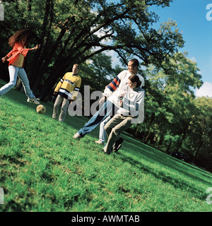 Les jeunes coups de ballon de football sur l'herbe Banque D'Images