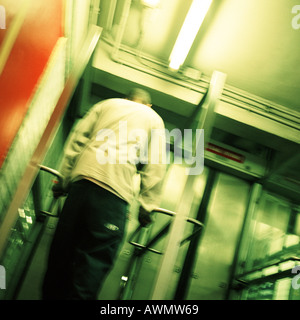 Jeune homme debout devant la porte de sortie du métro, vue arrière, low angle view Banque D'Images