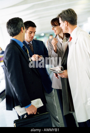 Business people standing together, l'un regardant le regarder Banque D'Images