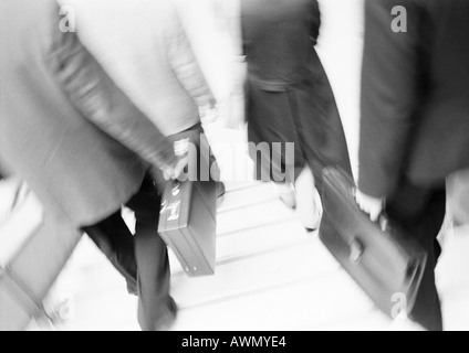 Les gens d'affaires walking down steps, partie inférieure, brouillées, b&w. Banque D'Images